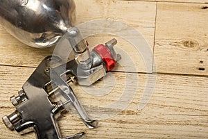 Paint spray on wooden floors Image of the painter`s arm hand holding industrial size spray gun used for industrial painting and c