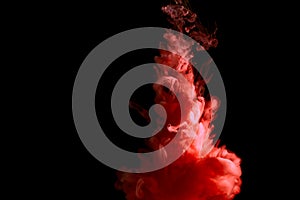 Paint stream in water, colored ink cloud, abstract background, process of liquefaction red dye on a black background