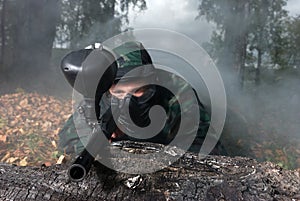 Paintball man aiming outdoor in smoke
