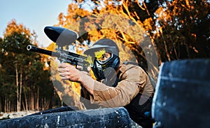 Paintball man with gun shooting target in forest battlefield, competition or games for fun adventure training. Aiming