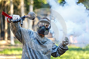Paintball player with marker and activated smoke grenade