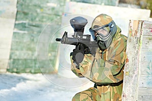 paintball player with marker at winter outdoors