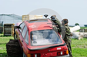 Paintballers hiding behind car