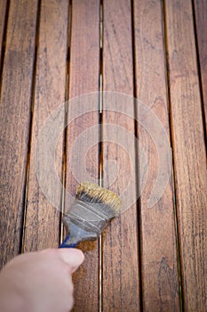 Paintbrush in hand and painting on wooden table