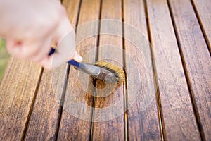 Paintbrush in hand and painting on wooden table