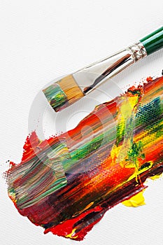 Paintbrush and mixed rainbow oil paints on artist canvas