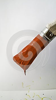 paintbrush with red paint dripping on white background
