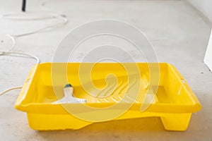 Paintbrush, roller and glue container on concrete surface. Composition tools for home repair and interior renovation