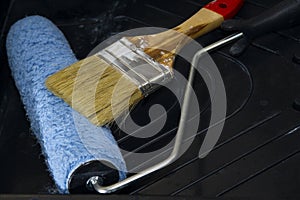 Paintbrush and roller paint on the tray