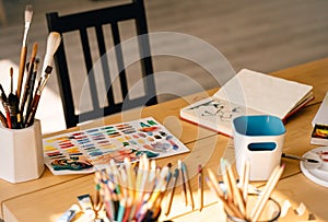 Paintbrush with tubes of oil paints and colour pencils. Art and craft tools,ink,wooden table.painting for contemporary artist`s.