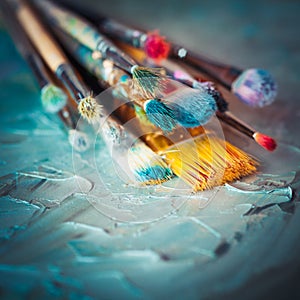 Paintbrushes on artist canvas covered with oil paints. photo