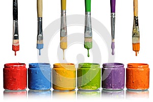 Paintbrushes Dripping into Paint Containers photo