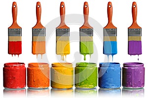 Paintbrushes Dripping into Paint Containers photo