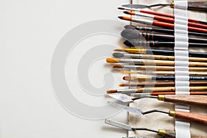 Paintbrushes and palette knifes in textile carry bag.