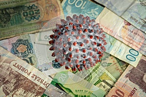 A painted ball like a SARS-CoV-2 virion on the middle of many banknotes from different countries
