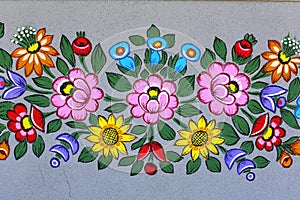 Painted beautiful floral pattern on the facade of an old house, Zalipie, Poland