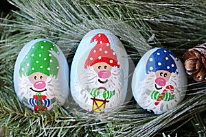 Painted Christmas Gnome Kindness Rocks on Evergreen Tree Branch photo