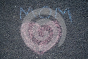 Painted colored chalk crayons heart word mom on the asphalt . concept of love and mother`s day