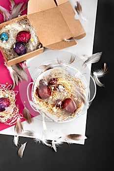 Painted Easter eggs in cardboard box and basket