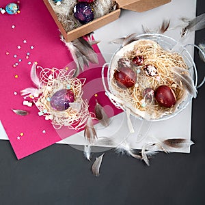 Painted Easter eggs in cardboard box and basket