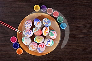 Painted Easter eggs, paintbrush and paint on the table. preparation for Easter. wooden table