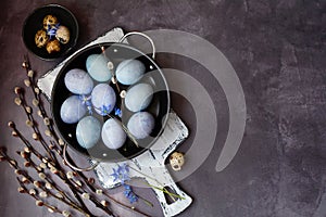 Painted Easter eggs in a plate and willow branches. Happy Easter concept