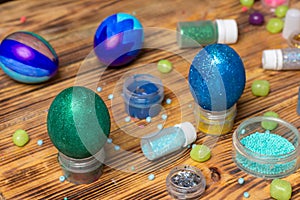 Painted easter glitter eggs, cans, sweets on table, food photography