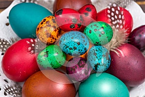 Painted eggs of different colors on a wooden table, Easter decoration,