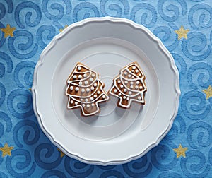 Painted gingerbread cookies in the shape of a Christmas tree on a plate