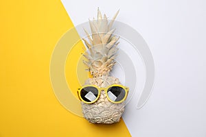 Painted gold pineapple with sunglasses on two tone background