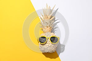 Painted gold pineapple with sunglasses on two tone background. Painted gold pineapple with sunglasses on two tone