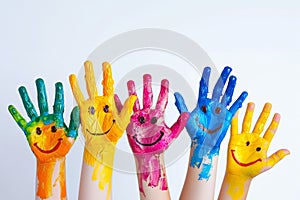 painted hands of children with smileys