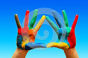 Painted hands, colorful fun. blue sky