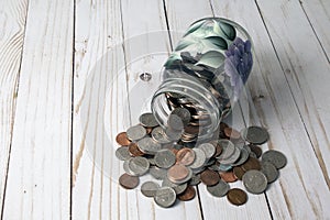 Painted mason jar on its side full of coins