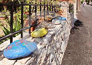 Painted pebbles as a decoration of a fence in a Greek village