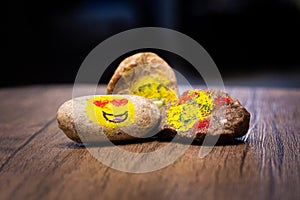 Painted pebbles with emoji faces on a table