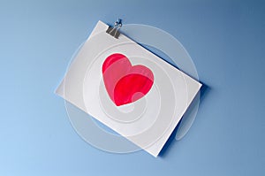 The painted red heart on white paper sheet love