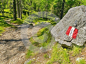 Painted red and white stripes on stone as a sign of directions navigation for tourists or people hiking and trekking, guideposts