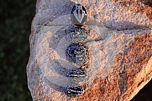 Painted rocks stating Groom, Best Man, Groomsman, and `I DO, and a tux photo