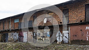 Painted rusty old warehouse doors on two-storey brick building. Background for design. Space for text