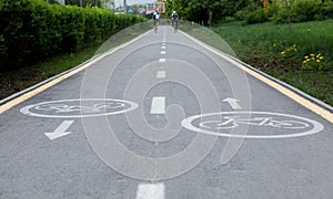 Painted signs on asphalt for bicycle dedicated lanes. A separate bike path in the city, cyclists on the cycle track