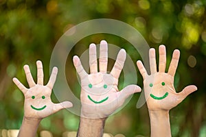 Painted smiley face on the palms against green background