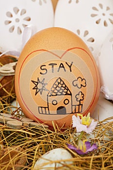 Painted `stay home` egg in easter wreath