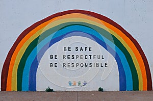 Painted wall with a rainbow and be safe, be respectful, be responsible motivational words