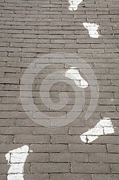 Painted white footprints on pavement