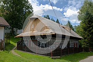 Maľovaný drevený domček s dreveným plotom