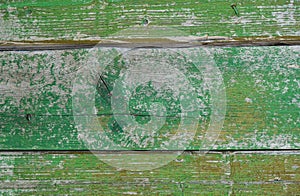 Painted wooden planks with cracked green paint