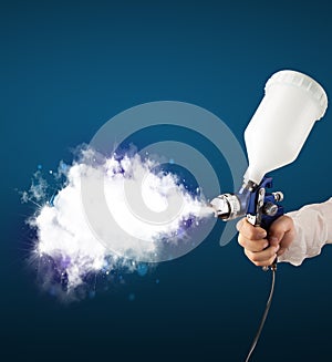 Painter with airbrush gun and white magical smoke