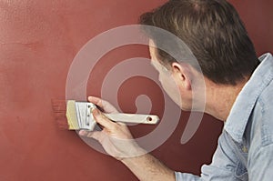 Painter Brushing Textured Red Wall