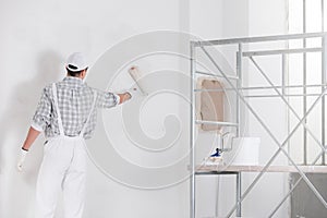 Painter or builder painting a wall white